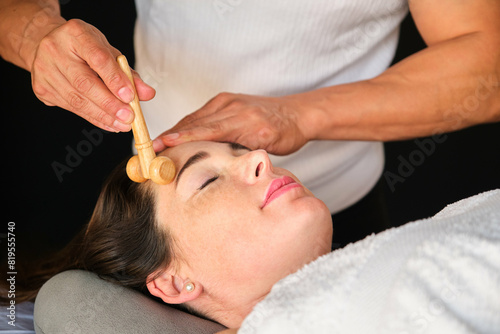 Woman getting face maderotherapy in a beauty salon. Professional skin care treatment. photo