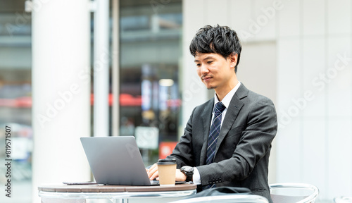 テラス席でノートパソコンを使う男性ビジネスマン photo