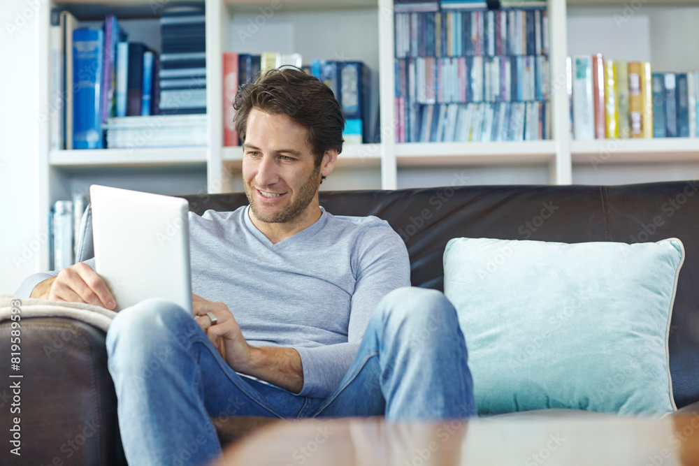 Man, relax and smile on sofa with tablet for internet streaming, online gaming and social media in living room of home. Person, happy and digital tech for reading ebook, web search or browse on couch