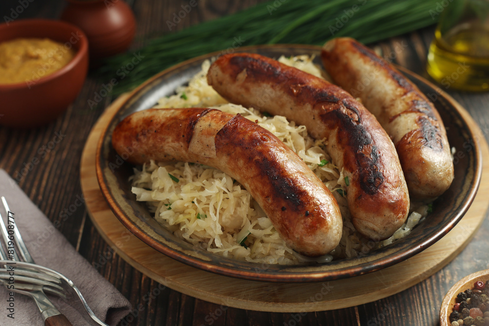 A bowl with Bratwurst and Sauerkraut as side dish - traditional German food A bowl with Bratwurst and Sauerkraut as side dish - traditional German food