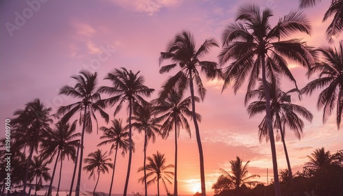 Silhouetted palm trees on a vibrant beach at sunset  creating a tranquil vacation scene.