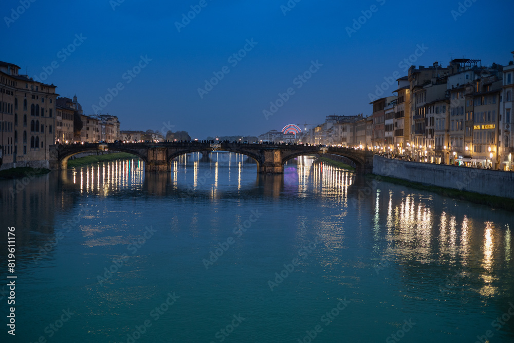 Arno River, view from Ponte Vecchio after Sunset, Reflections of Lights, Colours and the Ferris Wheel in Florence, Italy Arno River, view from Ponte Vecchio after Sunset, Reflections of Lights, Colours and the Ferris Wheel in Florence, Italy