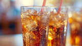 Close-up of refreshing cola with ice. A close-up shot of a refreshing glass of cola filled with ice cubes and a straw, capturing the fizz and bubbles rising to the top.