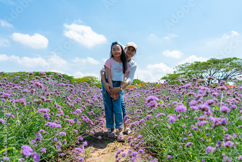 asian mother with daughter enjoy relaxing together in the flowers park,concept of love and family relationship,holiday.