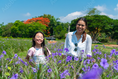 asian mother with daughter enjoy relaxing together in the flowers park,concept of love and family relationship,holiday.