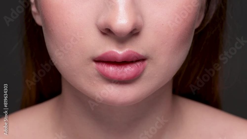 Young attractive woman with beautiful make-up and plump lips. She bites her lips