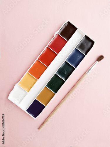 Brush and paint on a white background. Everything for drawing. Creation. Children is creativity. Hobby. Colored paints and gouache.