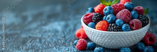 A white bowl filled with assorted berries and blueberries photo
