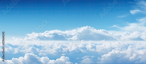 Sky filled with fluffy white clouds against a serene backdrop enhancing the beauty of the blue expanse and offering copy space image