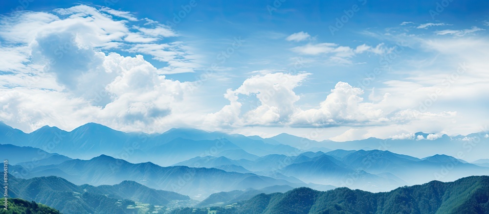The mountains are beautifully accentuated by a picturesque blue sky and fluffy white clouds creating an ideal copy space image