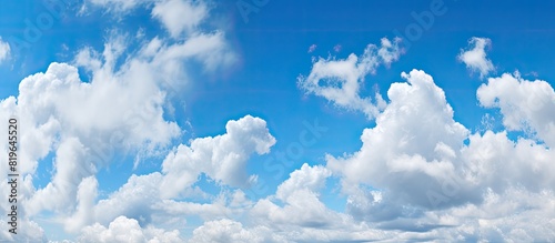 Panoramic view of a clear blue sky with white fluffy clouds ideal for copy space image