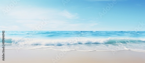 Seaside waves gently washing up onto a sandy beach with an expansive view of the horizon s copy space image