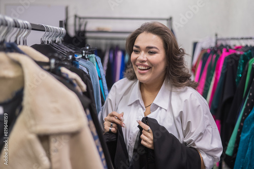 Portrait of a smiling fat woman choosing clothes in a plus size store. 