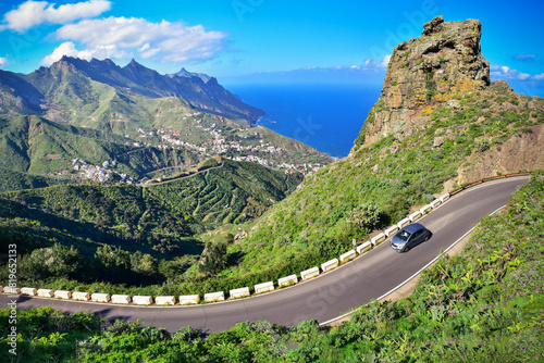 Driving car on winding road in verdant mountain landscape heading for the Atlantic Coast. Roadtrip North Tenerife, discover the Canary Islands.