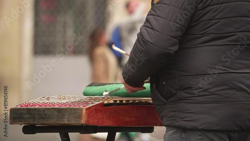 Playing Hammer Dulcimer. Street Performers Playing Chinese Hammered Dulcimer. Playing traditional musical instruments. Closeup hand play hammered dulcimer. dulcimer string and wooden bat photo