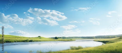 Sunny summer day featuring a river and a field with a serene landscape and copy space image © Ilgun
