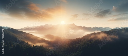 Aerial drone captures the sun s rays piercing through fog over the mountain forest creating a dramatic scene for a copy space image