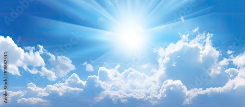 Light clouds in the sky with the sun shining through providing a serene backdrop against a blue sky with copy space image