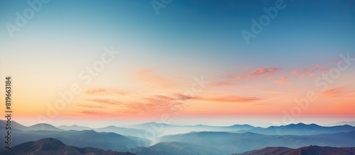 Scenic sunset sky over mountains with orange and blue hues offers a beautiful nature background ideal for a photo with copy space image