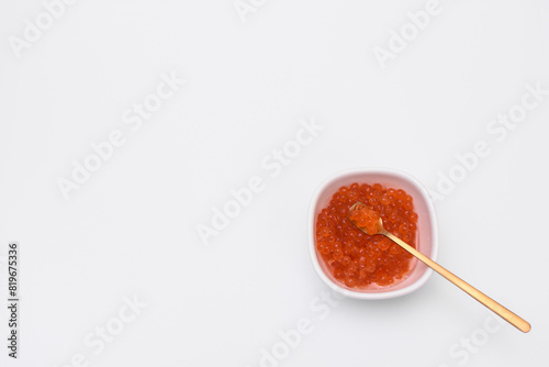 salmon red caviar in a saucer on a white background