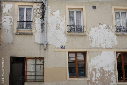 Pathologie d'une façade extérieure qui se détériore avec un décollement d'enduit photo