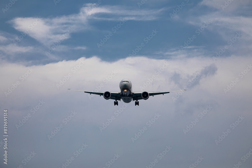 Fototapeta premium A big beautiful plane lands. Blue sky. Clouds in the sky.