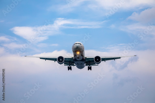 A big beautiful plane lands. Blue sky. Clouds in the sky.