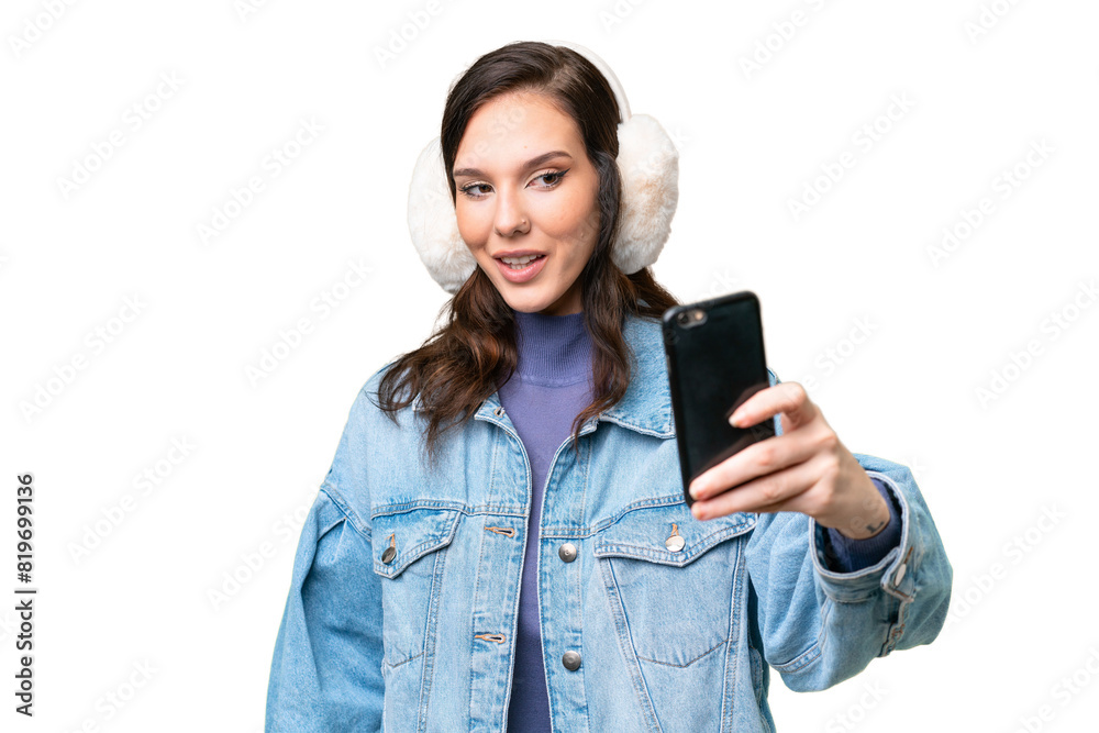 Young caucasian woman wearing winter muffs over isolated background making a selfie Young caucasian woman wearing winter muffs over isolated background making a selfie