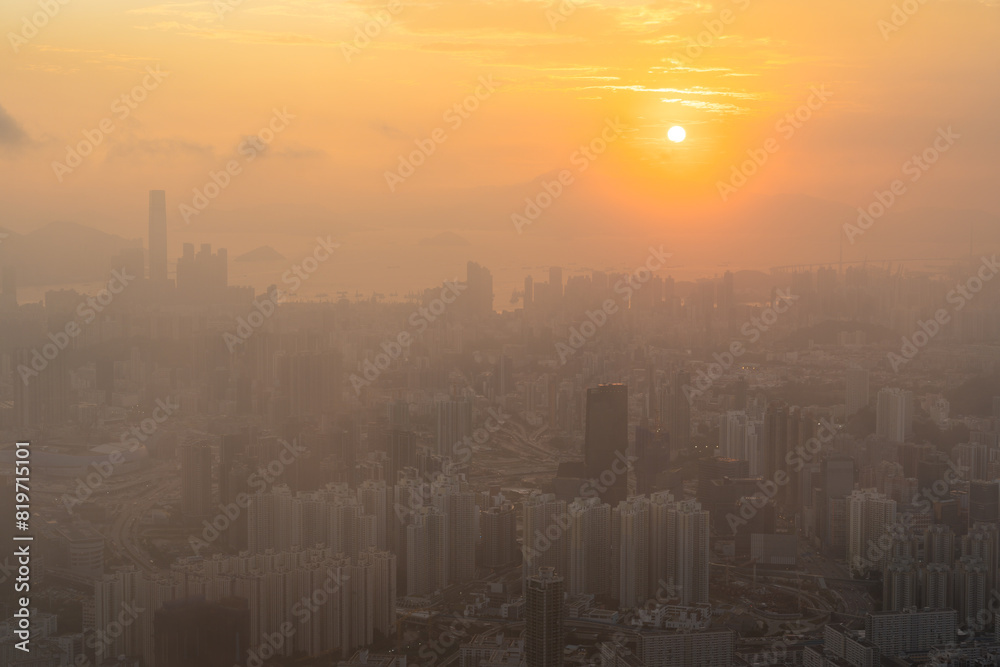Fototapeta premium Towering urban metropolis lining the coast, backed by scenic hills in Hong Kong during the sunset