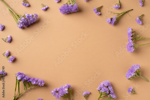 Violet flowers frame on brown background
