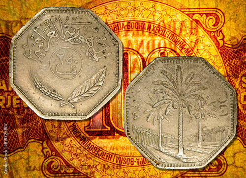 Vintage Libyan Jamahiriya dinar coins placed on a vibrant yellow tablecloth