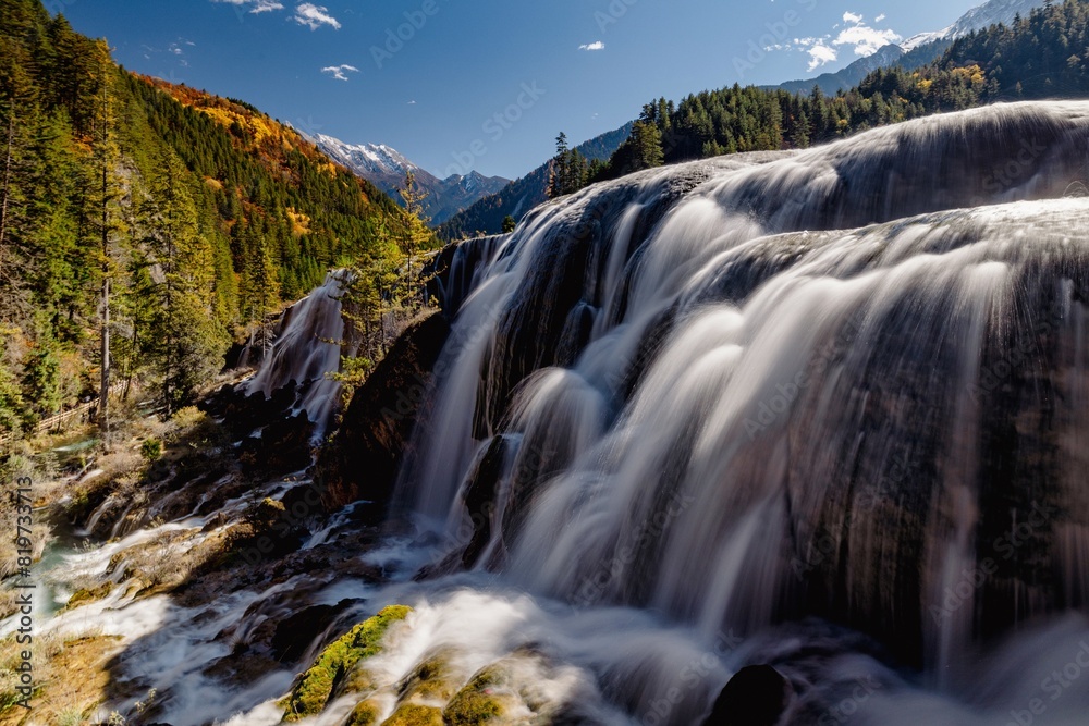 Beautiful waterfalls surrounded by green trees and mountains. Jiuzhaigou, China Beautiful waterfalls surrounded by green trees and mountains. Jiuzhaigou, China