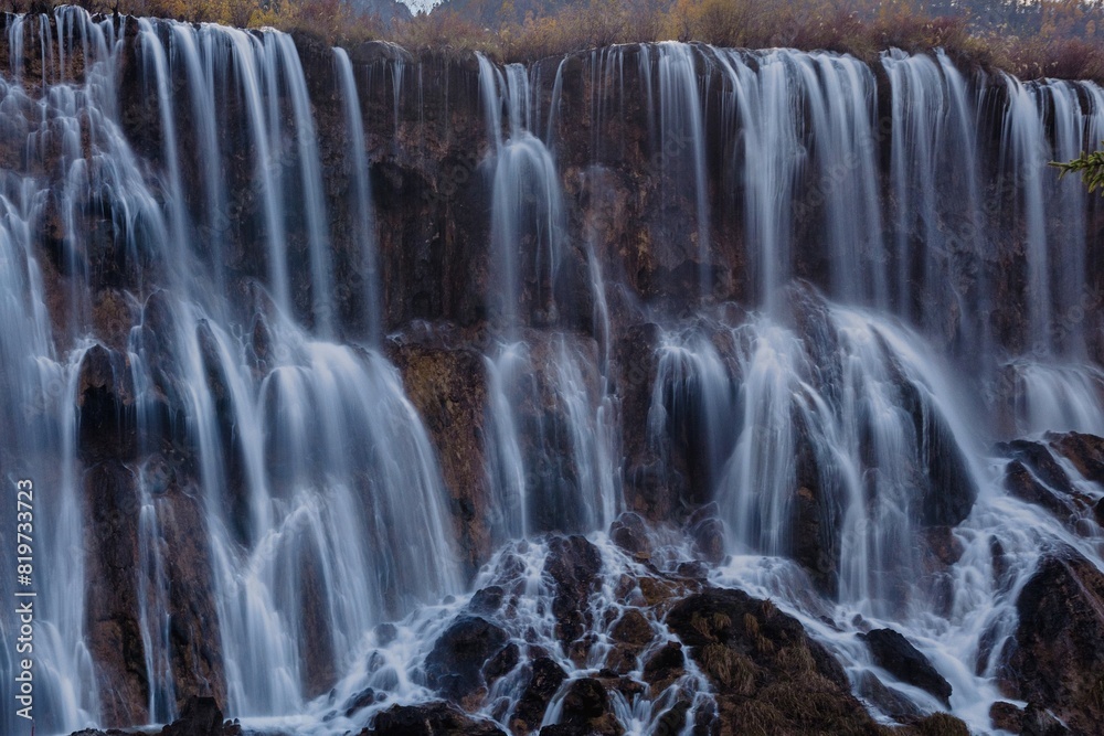 Fototapeta premium Magnificent cascade of water gracefully descends from cliffs. Jiuzhaigou, China