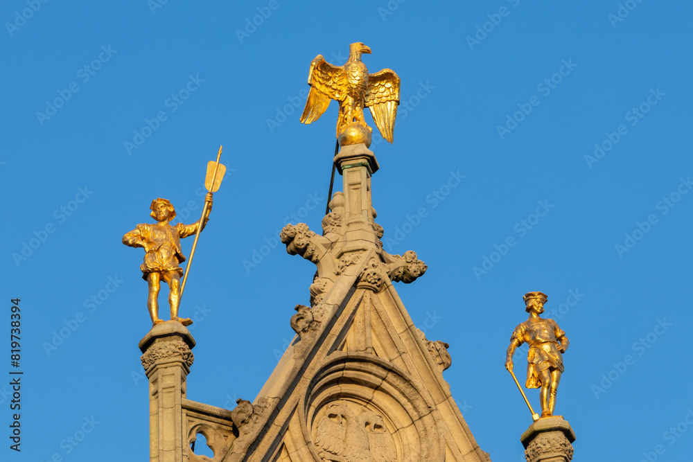Fototapeta premium Beautiful golden statues on the roof of s historical building in Antwerp, Belgium
