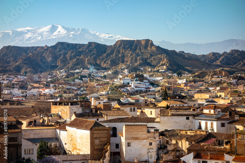 Scenic view of cave houses and snow-covered Sierra Nevada mountains in Guadix, Spain