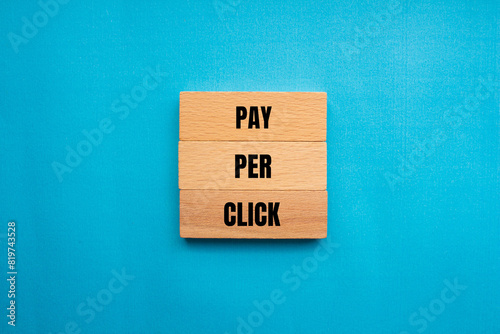 Pay per click words written on wooden blocks with blue background. Conceptual pay per click PPC symbol. Copy space.