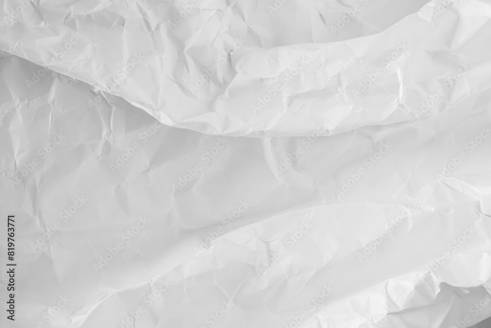 Obraz premium A heavily crumpled large sheet of paper as a background. Black and white image.