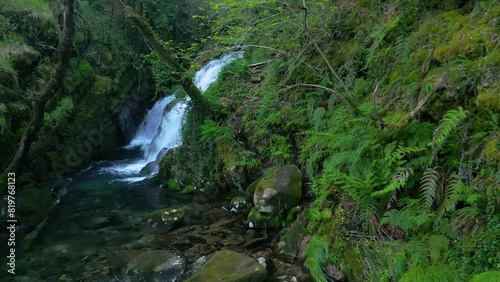 Scenery of tropical forest cascades flowing over moss-covered rocks at Santa Leocadia Waterfall photo