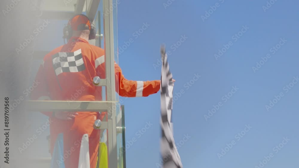 Man holding and waving Checkered race at finish line on a raceway. Victory, achievement, success and sport concept. Grand Prix.
