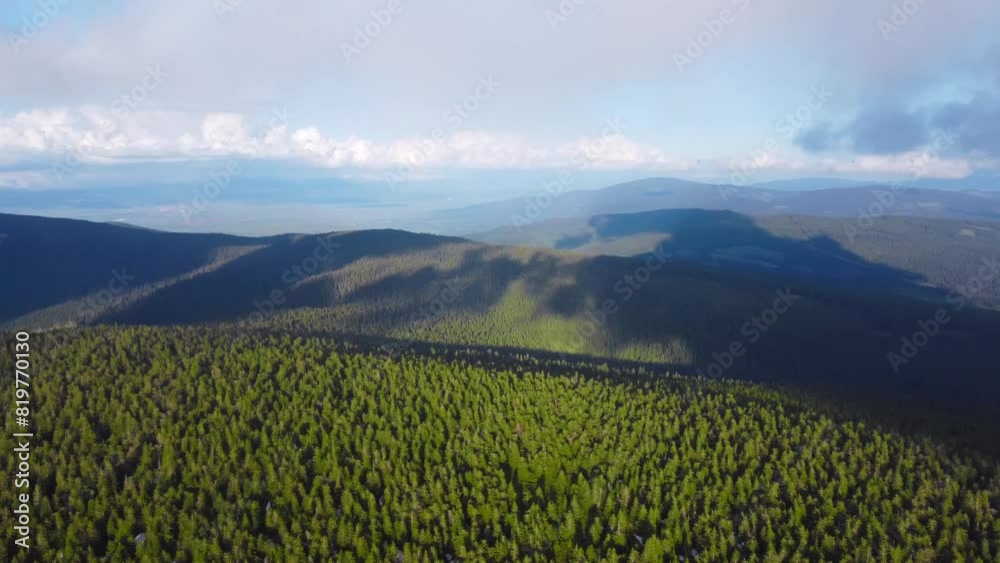 Aerial view of cloud shadows on mountains with coniferous forests Aerial view of cloud shadows on mountains with coniferous forests