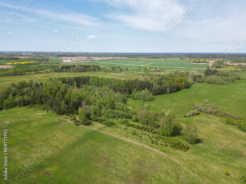 Aerial view of green forests surrounded by green farmland fields