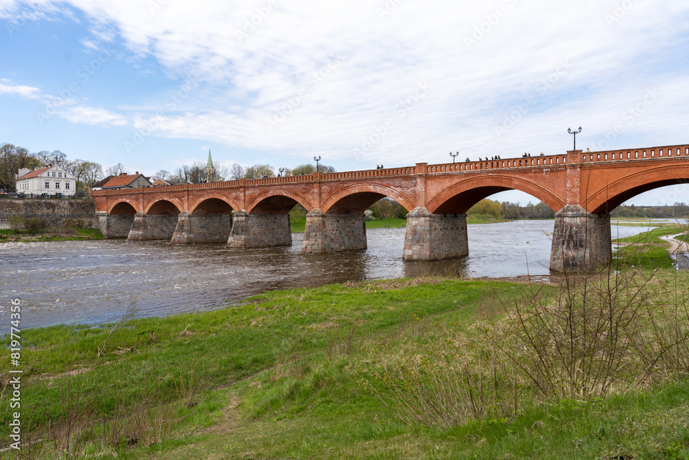 The old red brick bridge across the Venta river. Kuldiga, Latvia The old red brick bridge across the Venta river. Kuldiga, Latvia