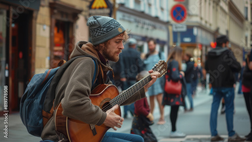 A pensive busker plays guitar on a bustling city street, sharing his music with passersby. photo