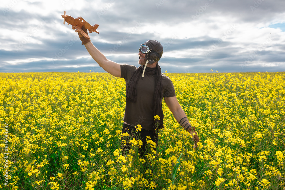 Man with toy airplane in vibrant yellow field Man with toy airplane in vibrant yellow field