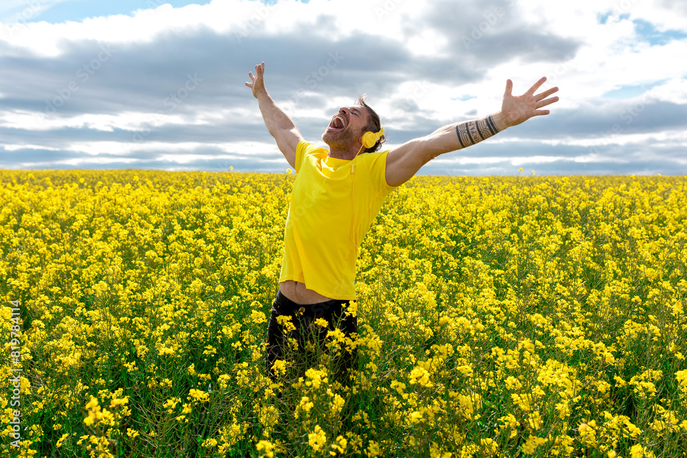 Man rejoicing in a vibrant yellow rapeseed field Man rejoicing in a vibrant yellow rapeseed field