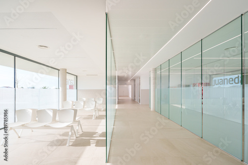 Modern hospital corridor with seating and glass partitions photo