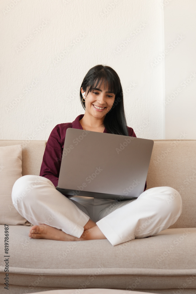 Woman comfortably working at home on sofa with laptop Woman comfortably working at home on sofa with laptop