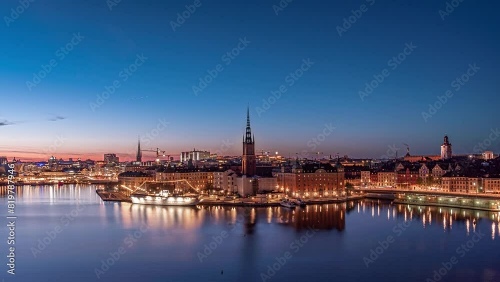 Time lapse of Stockholm, Riddarholmen, the old town, church, at night in summer, green aurora borealis, northern lights partly visible in the sky. Orange and yellow city lights, city skyline Time lapse of Stockholm, Riddarholmen, the old town, church, at night in summer, green aurora borealis, northern lights partly visible in the sky. Orange and yellow city lights, city skyline