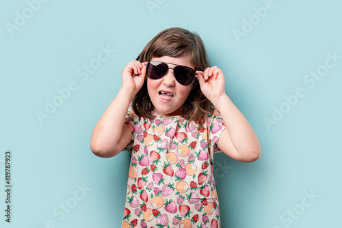 Young girl smiling and adjusting her sunglasses photo