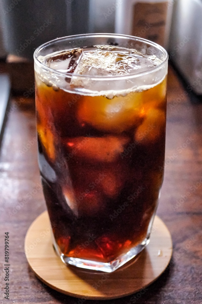 Iced coffee beverage served on a wooden coaster Iced coffee beverage served on a wooden coaster